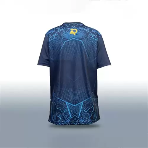 AR 11 Eye Blue Color Cricket Shirt back view featuring a dark navy blue short-sleeve cricket shirt with an intricate bright blue geometric pattern across the upper back and lower section. The upper back displays detailed blue linework, including curved outlines around the shoulders, angular shapes, and a fine grid-like pattern that extends toward the center. A yellow and blue AR-style emblem is positioned at the upper center of the back, just below the neckline. The central back area is predominantly dark navy blue, with subtle blue grid lines forming symmetrical geometric shapes that continue down toward the hem. The lower back features elaborate blue outlined graphics and angular patterns that create a distinctive design along the bottom of the shirt. The sleeves are plain dark navy blue, providing contrast against the patterned back, while the shirt has a rounded neckline, a relaxed athletic fit, and a slightly curved lower hem. It is displayed upright against a plain white and light gray studio background with soft lighting and a subtle shadow underneath, clearly showing the back design, colors, and graphic details. This image shows the back side of the AR 11 Eye Cricket Shirt – Blue Color, available across Pakistan with online delivery from AR Sports.