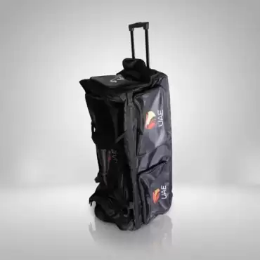 AR Sports Coffin Cricket Kit Bag shown against a clean white and light gray studio background. The black cricket kit bag stands upright in the center, featuring a tall, rectangular coffin-style design with multiple zippered compartments, reinforced fabric panels, and side pockets for storing cricket equipment. Two AR Sports UAE logos with red, yellow, and orange graphics are visible on the side compartments. A telescopic pull handle extends from the top, making the bag convenient to transport, while its wheeled design supports easy movement. The bag has a durable-looking black exterior with visible stitching, zippers, and separate storage sections for organizing cricket gear. The image showcases the AR Sports Coffin Cricket Kit Bag, designed for cricketers who need practical storage and transportation for their equipment, available for online purchase and home delivery across Pakistan.