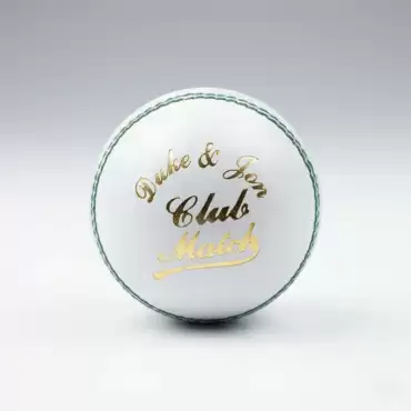 Dukes White Color Hard Ball shown against a clean light gray studio background. The white leather cricket ball is positioned upright in the center, with its raised stitched seam clearly visible around the outer edge. The front of the ball features the “Dukes & Sons Club Match” branding in gold and black lettering, while the green stitching around the seam creates a visible contrast against the white leather surface. The ball has a traditional hard cricket ball shape and 4-piece stitched construction. Soft studio lighting creates a subtle shadow underneath the ball and highlights its smooth leather finish. The image showcases the Dukes White Color Hard Ball, available for online delivery across Pakistan.
