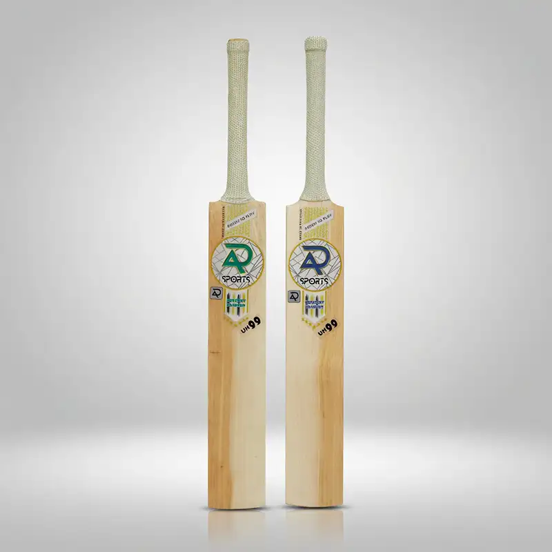 AR Sports uh99 English Willow Cricket Bat Two AR Sports UH99 English Willow cricket bats standing upright side by side against a clean light gray background. Both bats feature light-colored natural wood blades with visible grain, long handles covered with textured light-colored grips, and AR Sports branding with the UH99 model marking printed on the front of each blade. The bats have traditional flat faces and squared lower edges, with soft shadows and a subtle reflection beneath them from the studio lighting. The image showcases the AR Sports UH99 English Willow Cricket Bat, available for purchase with delivery across Pakistan.